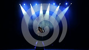 Silhouette of the singer performing on stage.