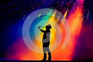 Silhouette of a singer on stage with a colorful light show in the background. Generative AI