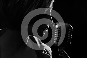 Silhouette of singing woman with retro microphone