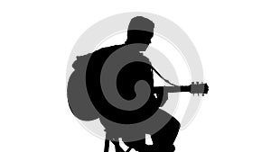 Silhouette of sitting man playing the guitar on a