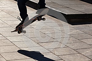 Silhouette of a skateboarder who jumps on the street in the city on a skateboard.