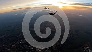 Silhouette of skydivers at sunrise.