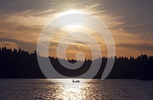 Silhouette of small boat in golden sunset.