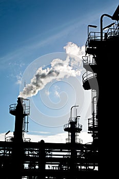 Silhouette of smokestack in petrochemical plant