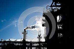 Silhouette of smokestack in petrochemical plant