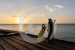 Silhouette of snorkeling and scuba diving equipment against a sunset in the Caribbean Sea