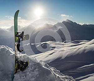 Silhouette of snowboard standing upright in snow