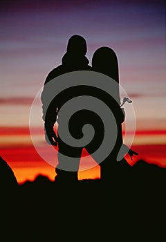 Silhouette of snowboarder against sunset