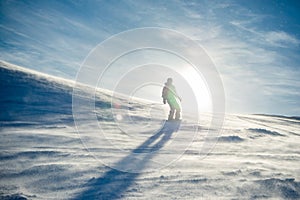 Silhouette of Snowboarder Riding Snowboard in the Mountains at Sunny Day in Snowstorm. Snowboarding and Winter Sports
