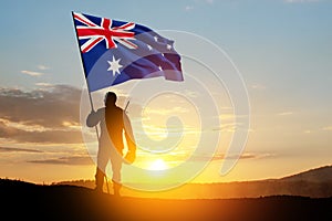 Silhouette of soldier with Australia flag on background of the sunset or the sunrise background. Anzac Day.