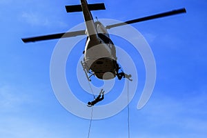 Silhouette Soldier Jump rope from helicopter in blue sky