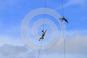 Silhouette Soldier Jump rope from helicopter in blue sky