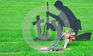 Silhouette of Soldier Kneeling in Veterans Cemetery