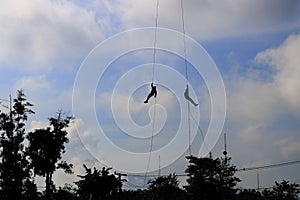 Silhouette Soldier rappelling from helicopter in blue sky