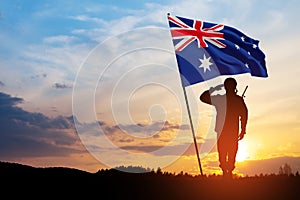 Silhouette of soldier saluting with Australia flag on background of the sunset or the sunrise background. Anzac Day.