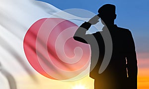 Silhouette of soldier saluting on background of susnset with Japan flag. Japan Armed Force Concept