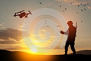 Silhouette of soldier are using drone and laptop computer for scouting during military operation.