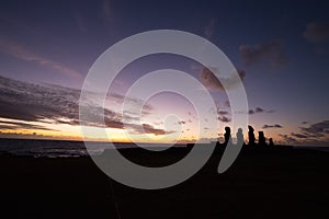 Silhouette of some giant statues of Easter Island at sunset. The moai of the Ahu Tahai Ceremonial Complex, Hanga Roa, Easter