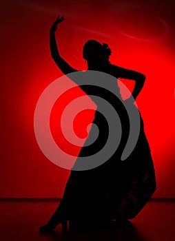 Silhouette of spanish girl flamenco dancer on a red background