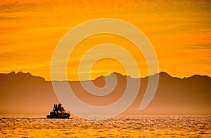 Silhouette of Speed boat in the ocean at sunset.