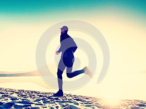 Silhouette of sport active man running on the lake beach at sunrise. Healthy lifestyle.