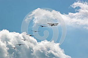 Silhouette sport aircraft with propeller and gliders, plane pulling a six against the blue sky in the air show performance.