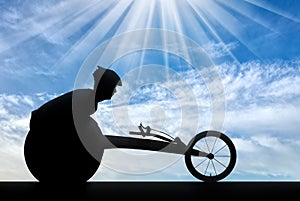 Silhouette of sportsman disabled in a racing wheelchair