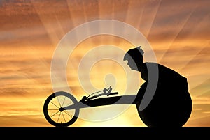 Silhouette of sportsman disabled in a racing wheelchair
