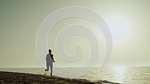 Silhouette sportswoman running seashore. Girl jogging sandy beach at sunset.