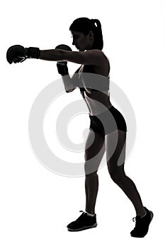 Silhouette sporty woman doing boxing exercises, making direct hit with dumbbells. Photo of muscular female wearing sportswear on w