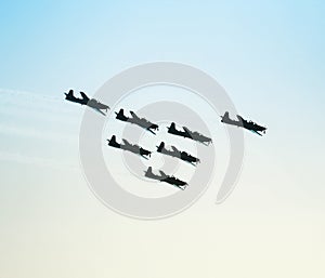 Silhouette of a squad of seven airplanes flying together