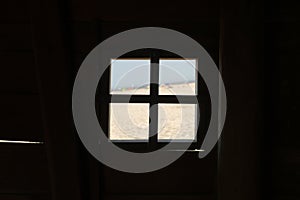 Silhouette of a square-shaped window in a building with a beach view