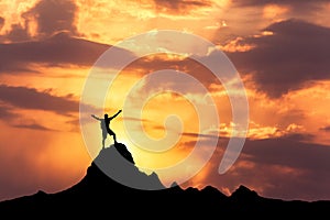 Silhouette of a standing happy man on the mountain peak