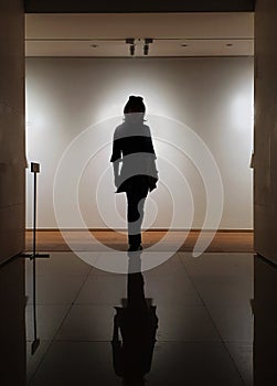 A silhouette standing shadow of woman indoor museum