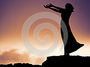 Silhouette of a statue of a woman, her hands outstretched in prayer. Waiting on a shore, Rosses point, coutny Sligo, Ireland