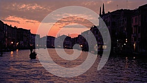 Silhouette of strong gondolier riding boat with long oar