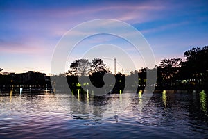 Silhouette sunset in the evening the tree is shadows dark. There are ponds that reflect light Blue sky and clouds