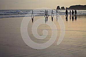 Silhouette of surfers heating up going to swim in morning sunrise