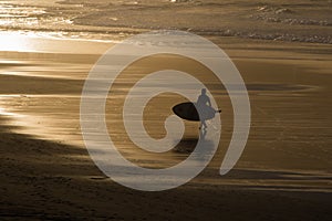 Silhouette of surfers in scenic golden sunset on hendaye beach, basque country, france