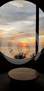 Silhouette of table and window with sea, sky, coconut tree and sunset or sunrise background at Bangsaen beach Chonburi, Thailand.