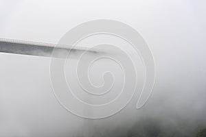 Silhouette of a tall modern bridge covered by mist