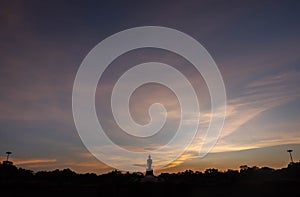 Silhouette technique under golden twilight evening sky with Walking Buddha statue in Thailand