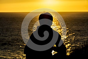 Silhouette of a teenager boy on sunset