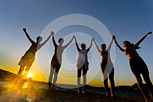 Silhouette of teens at sunset on the beach, happiness concept