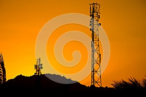 Silhouette of telecommunication antenna cellular tower for telephony with beautiful sunset