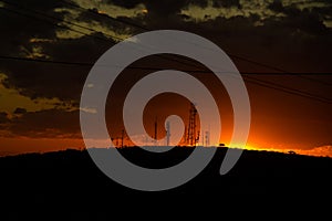 Silhouette of telephone antennas with a beautiful sunset in the background