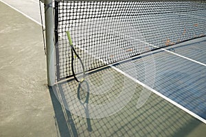 Silhouette of tennis net and racket on court