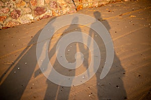 Silhouette of three people on the sand