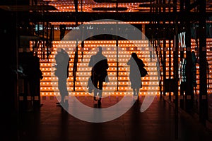 Silhouette of three persons with an orange background