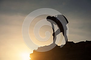 Silhouette tired woman at cliff hill peak